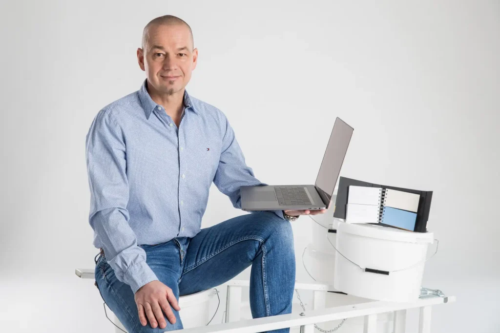 Hannes Herbsthofer mit Laptop und Farbkübeln